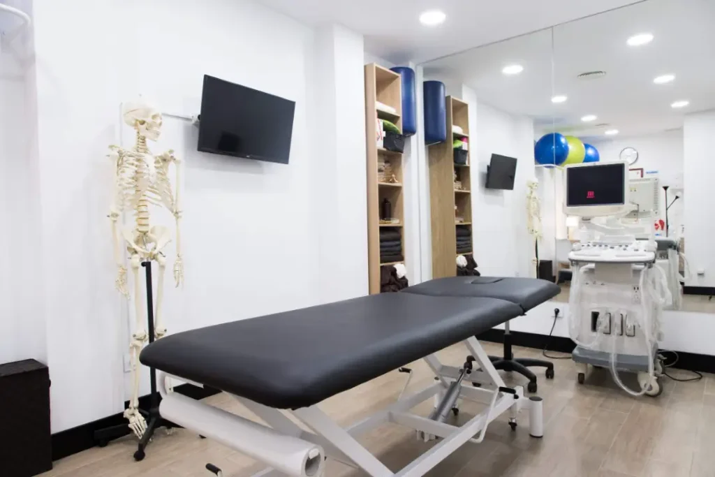 Sala de fisioterapia con camilla y modelo anatómico