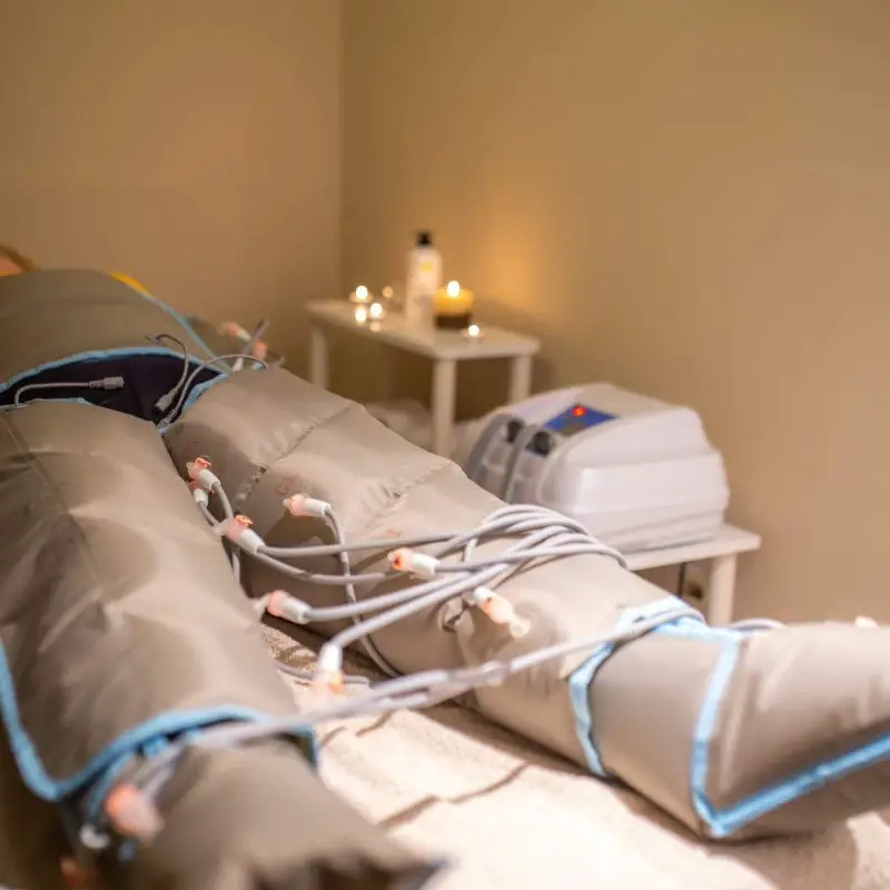 Paciente con prendas de compresión conectadas a un equipo de presoterapia